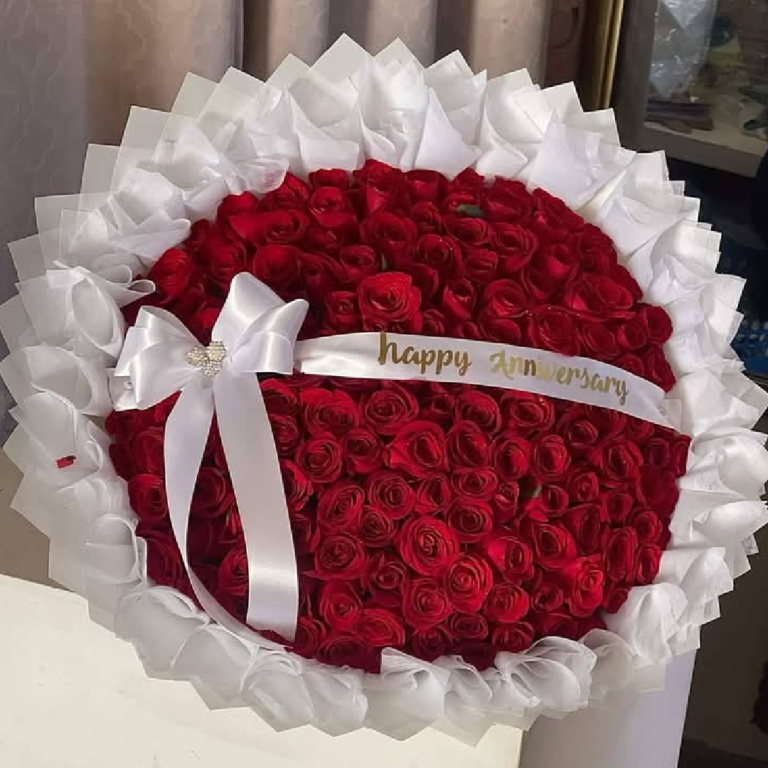 Ramo buchón de aniversario con rosas rojas y papel de olanes blancos los cabos